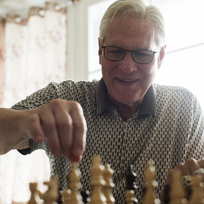 Senior resident playing chess for memory care